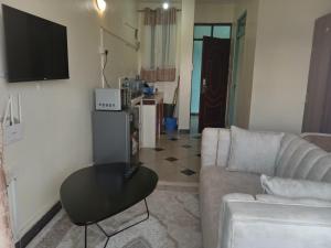 a living room with a couch and a table at Tamara Studio Apartment in Shanzu in Mtwapa