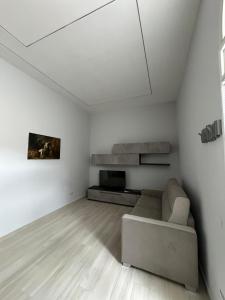 sala de estar blanca con sofá y TV en Villa Rose Apartments, en Sant'Egidio del Monte Albino