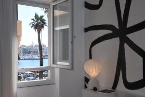 Pokój z oknem z palmą i lampą w obiekcie Ortigia Riflessa - design e comfort vista mare w Syrakuzach