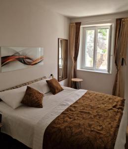 a bedroom with a large bed and a window at Old Town Apartment in Omiš