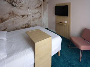 Habitación de hotel con cama y TV en ibis Styles Chinon, en Chinon
