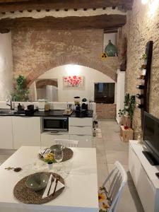 eine Küche mit einem weißen Tisch und einer Steinmauer in der Unterkunft I Fiori di Colle, l’anima Toscana “Loft” in Colle di Val d’Elsa