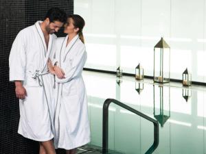 a man and a woman in white robes standing next to a pool at Sofitel Casablanca Tour Blanche in Casablanca