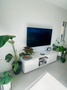 a white entertainment center with a flat screen tv at Royal View Apartment - Playa de Las Americas in Playa de las Americas
