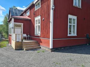 ein rotes Haus mit einer Veranda und einer Treppe darauf in der Unterkunft Nice Teachers Apartment In Old School 