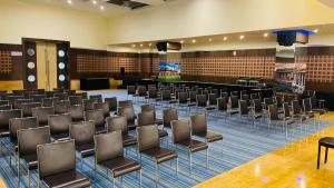 a conference room with rows of chairs and a stage at Royal Orchid Central Kireeti Hampi in Hampi