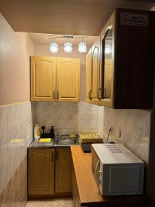 a kitchen with wooden cabinets and a sink and a microwave at Galant Hotel in Wieliczka