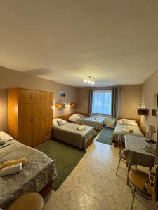 um quarto de hotel com três camas e uma janela em Galant Hotel em Wieliczka