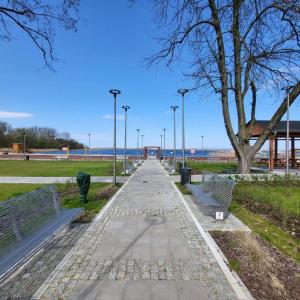 uma passarela com bancos e luzes de rua num parque em Sail & Fun Team Szczecin - Rejsy Jachtem - Jacht Czartery em Szczecin