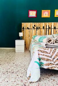 um quarto com uma cama e uma parede verde em The Green House on the sea em Pozzallo