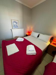 a bedroom with a large bed with a red blanket at xara house in (( Filaréton ))