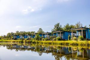 una fila de casas junto a un cuerpo de agua en Vakantiepark Vlinderloo en Enschede