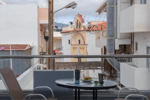 a table on a balcony with a view of a building at antéste Ierapetra sea & city in Ierapetra