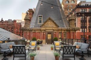 an outdoor patio with chairs and a building at The Beekman, A Thompson Hotel, by Hyatt in New York