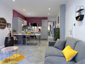 a living room with a couch and a kitchen at GÎTE **** L'ATELIER DU TONNELIER in Ribeauvillé