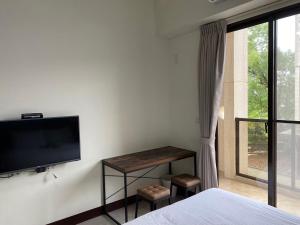 a bedroom with a bed and a tv on a wall at 羅東旅行家民宿 in Luodong