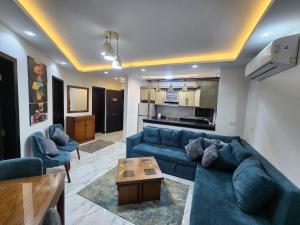 ein Wohnzimmer mit einem blauen Sofa und einem Tisch in der Unterkunft Porto said بورتوسعيد غرفتين وصاله in Port Said