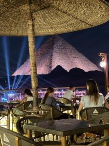 a group of people sitting at a table at a restaurant at Basha Pyramids inn in Cairo