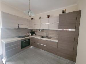 a kitchen with white cabinets and a sink at La casa di Fiona in Quartu SantʼElena