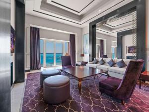 Rixos Marina Abu Dhabi في أبوظبي: غرفة معيشة مع أريكة وطاولة