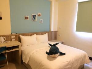 a black cat sitting on a bed in a room at 羅東旅行家民宿 in Luodong