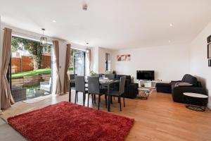 a living room with a table and a red rug at Luxury Three Bedrooms Flat, Coulsdon CR5 in Coulsdon