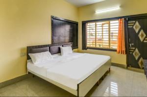 een slaapkamer met een groot bed en een raam bij Hotel Moon Near Sea Beach & Jagannath Temple - Best Seller in Puri