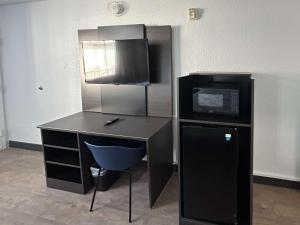 a desk with a microwave and a computer in a room at Motel 6 Fort Worth, TX East in Fort Worth