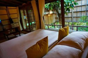 Ban Nam Tokにあるเรือนคุณแม่の大きな窓のある部屋にある大きなベッド