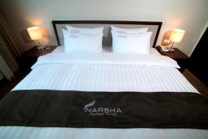 uma cama com um cobertor nasa com duas lâmpadas em Yeosu Narsha Hotel em Yeosu