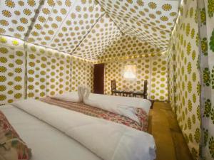una camera con letto in una stanza con pois di Sam Safari Resort Jaisalmer a Jaisalmer