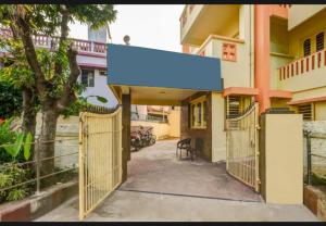 een poort naar een huis met een blauwe luifel bij Hotel Moon Near Sea Beach & Jagannath Temple - Best Seller in Puri