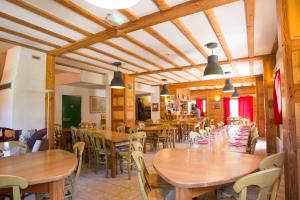 a dining room with wooden tables and chairs at Hôtel L'Echaillon in Névache