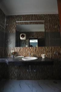 a bathroom with a sink and a mirror at Vagmi Inn in Gurgaon