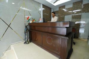 a man sitting at a counter in an office with a piano at Vagmi Inn in Gurgaon