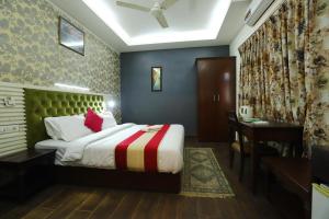 a hotel room with a bed and a desk and a table at Vagmi Inn in Gurgaon