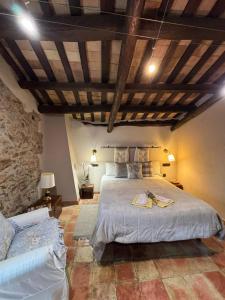 - une chambre avec un grand lit et un mur en pierre dans l'établissement Can Toni Vell Espinelves, à Espinelvas