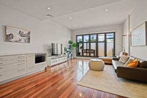 a living room with a couch and a tv at Trendy 3 Level Retreat at North Melbourne with parking in Melbourne