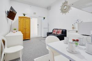 een witte woonkamer met een witte tafel en stoelen bij Azure Beach Hotel in Bournemouth