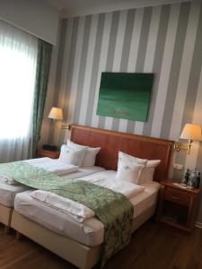 Self-Service by Hotel Savoy Hannover في هانوفر: غرفة نوم بسريرين ولوحة خضراء على الحائط