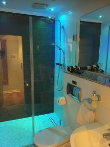 y baño con ducha, aseo y lavamanos. en Self-Service by Hotel Savoy Hannover en Hannover