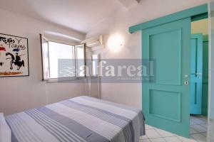 een slaapkamer met een bed en een blauwe deur bij Mare Bilo in Castiglione della Pescaia