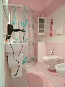 Baño rosa con lavabo y aseo en Casa vacanze valentino, en Avola