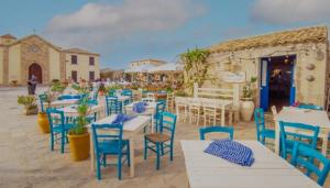 a group of tables and chairs with blue chairs at Casa vacanze valentino in Avola