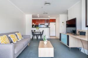 a living room with a couch and a table at Spectacular Darling Harbour View & Parking in Sydney