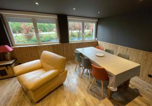 a room with a couch and a table and chairs at Les Loutrons in Cornimont