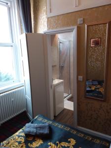łazienka z prysznicem i łóżko w pokoju w obiekcie IVY- Braveheart Guest House w Edynburgu