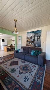 uma sala de estar com um sofá e um tapete em Casa das Plantas em Gravatal
