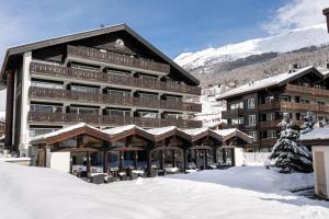 a large building with snow in front of it at Mirabeau Etoile in Zermatt
