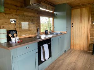 a kitchen with a sink and a stove at The Showman, Luxury Camper in Halford